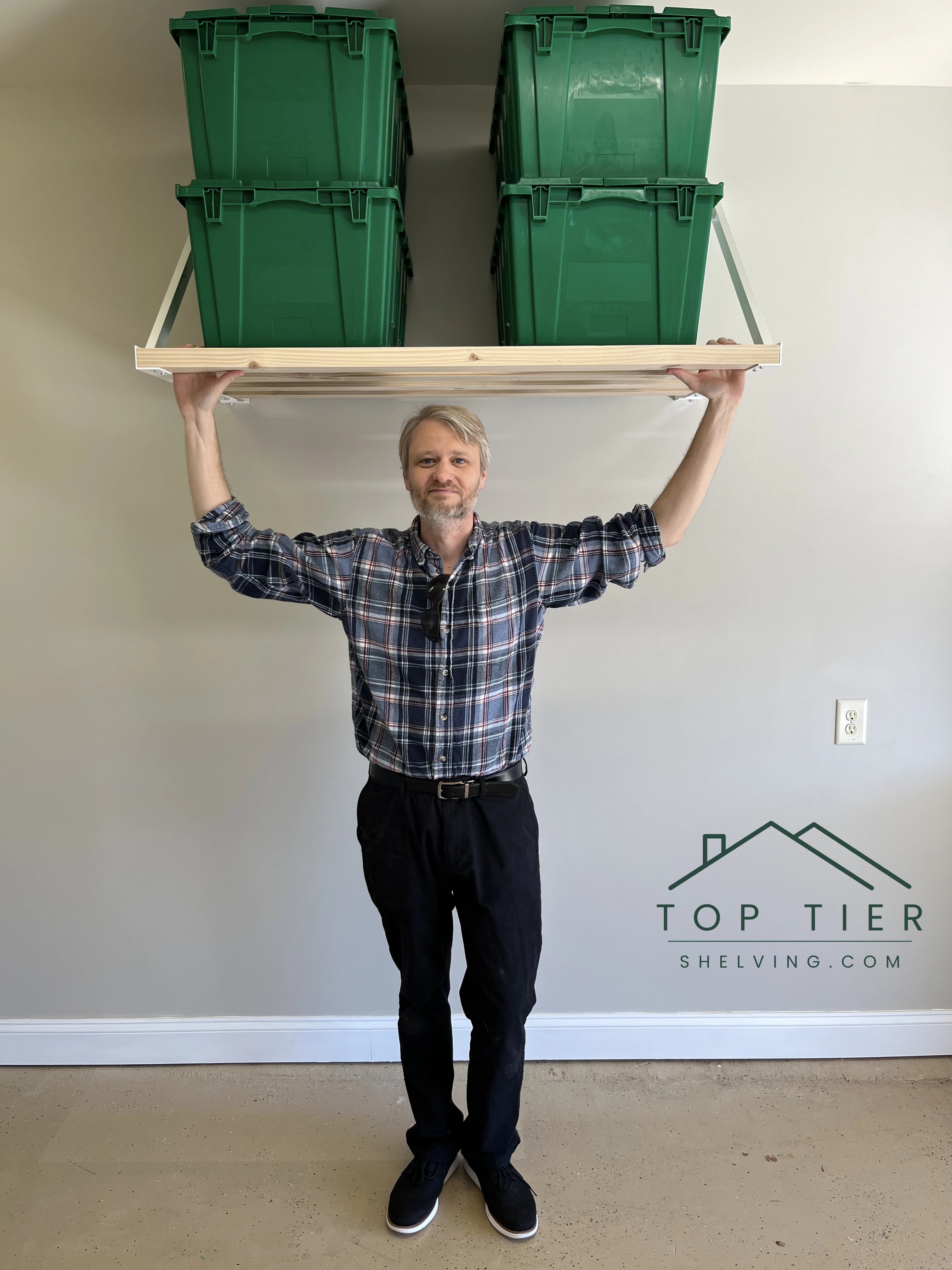 doc in the plaid shirt from top tier shelving standing under a professionally installed aluminum garage storage shelving system